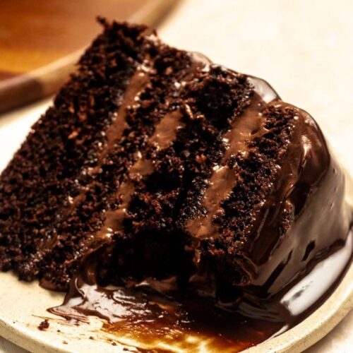 Bite missing from a slice of chocolate cake with chocolate mousse.