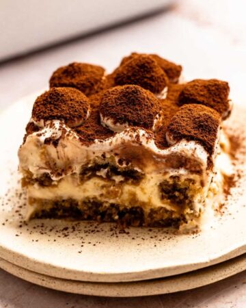 Slice of Italian tiramisu with cocoa powder on top.