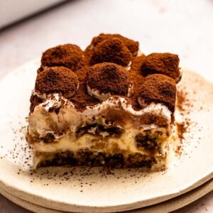 Slice of Italian tiramisu with cocoa powder on top.