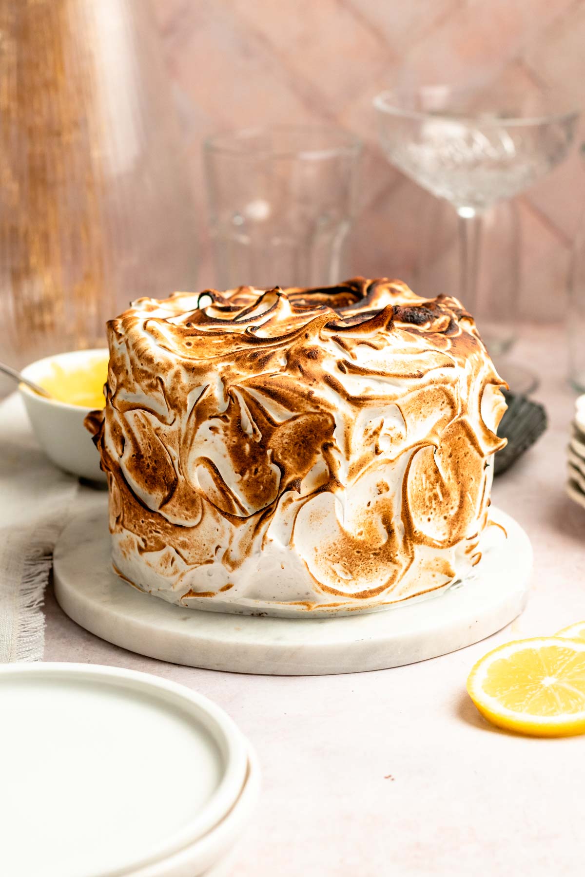 Lemon meringue cake on a marble plate.
