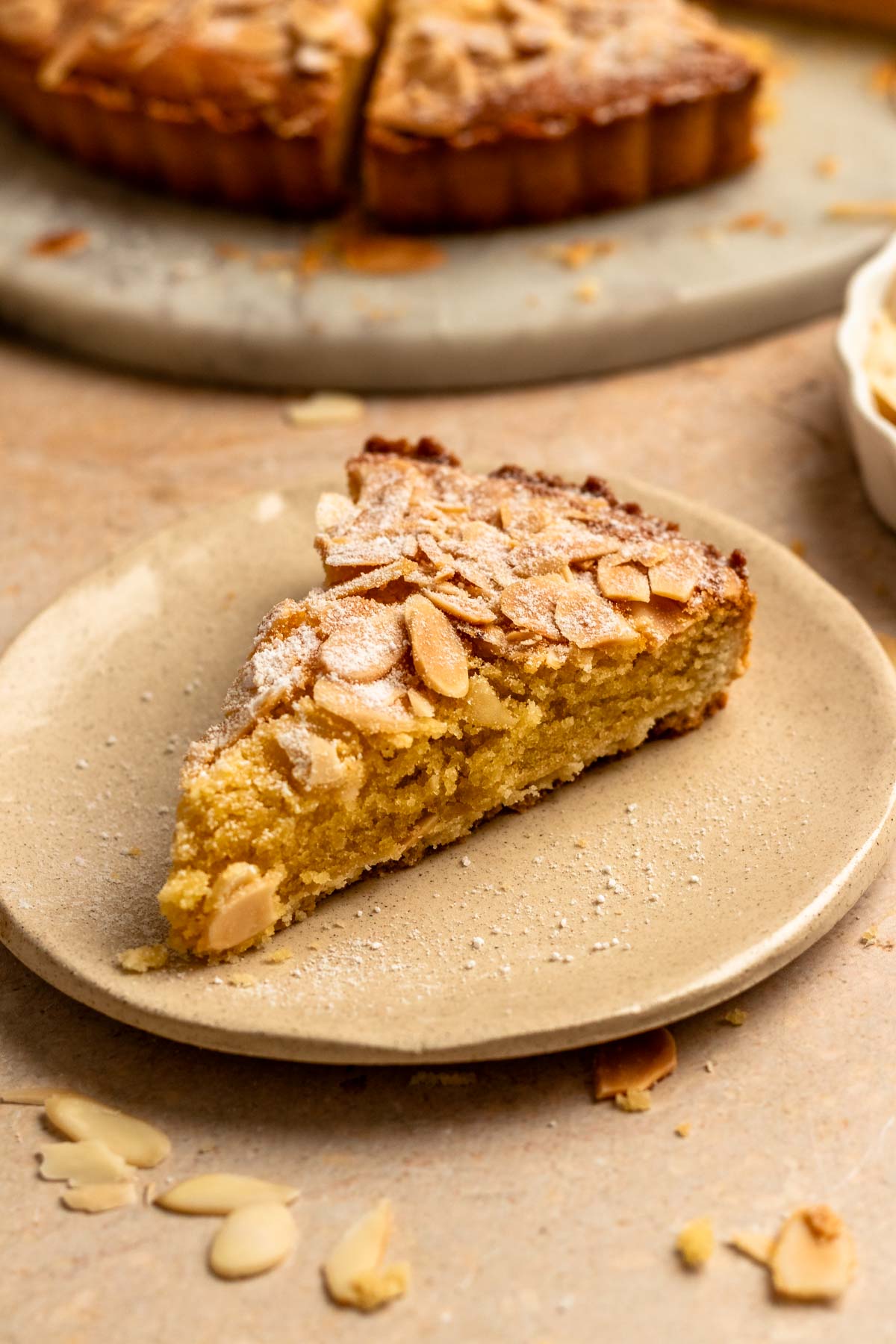 Slice of an almond tart on a plate.