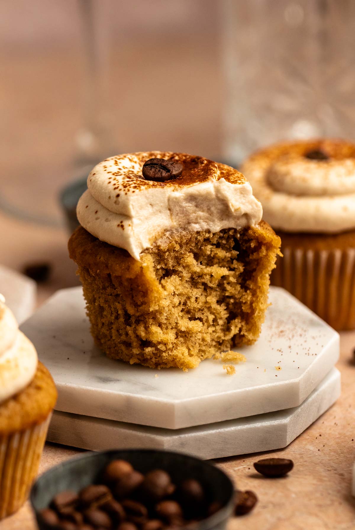 Bite missing from a coffee cupcake.