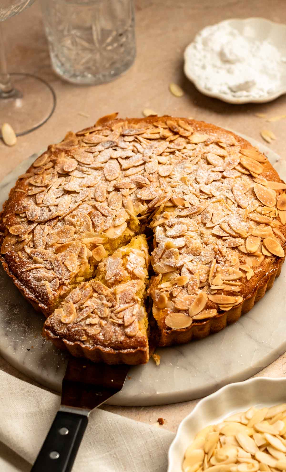 Slice pulled away from an almond tart.