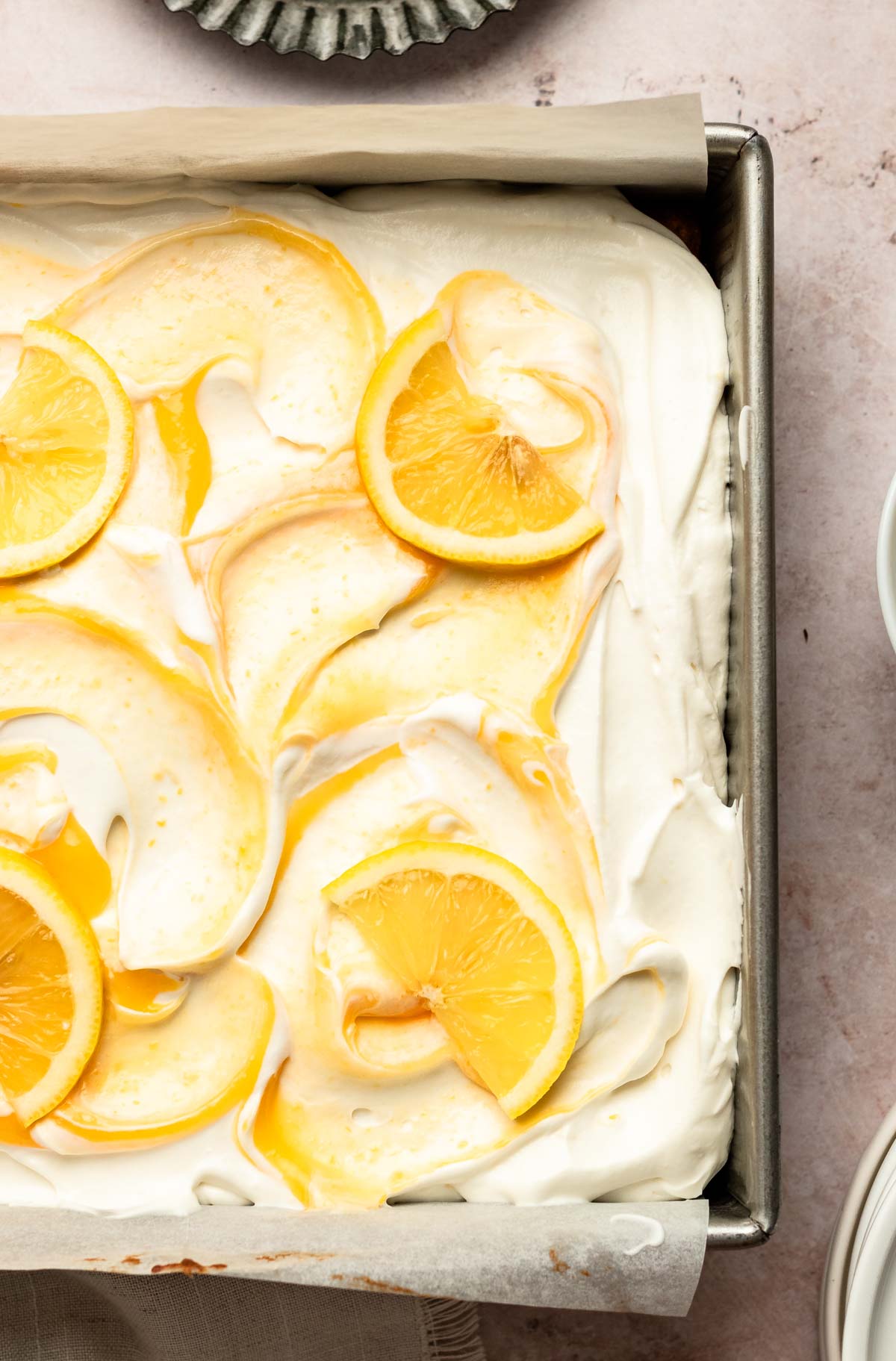 Top of lemon sheet cake with lemon sliced on top.