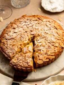 Slice pulled away from an almond tart.