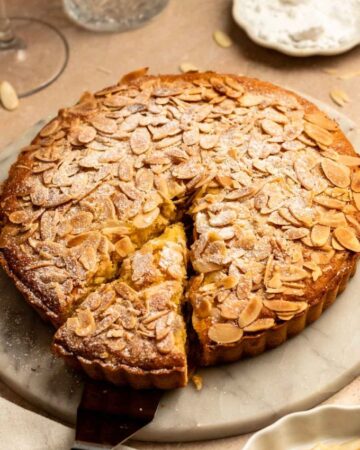 Slice pulled away from an almond tart.