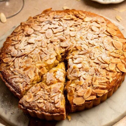 Slice pulled away from an almond tart.