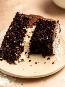 Bite missing from a coconut chocolate cake.