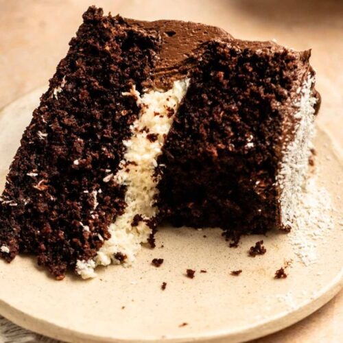 Bite missing from a coconut chocolate cake.