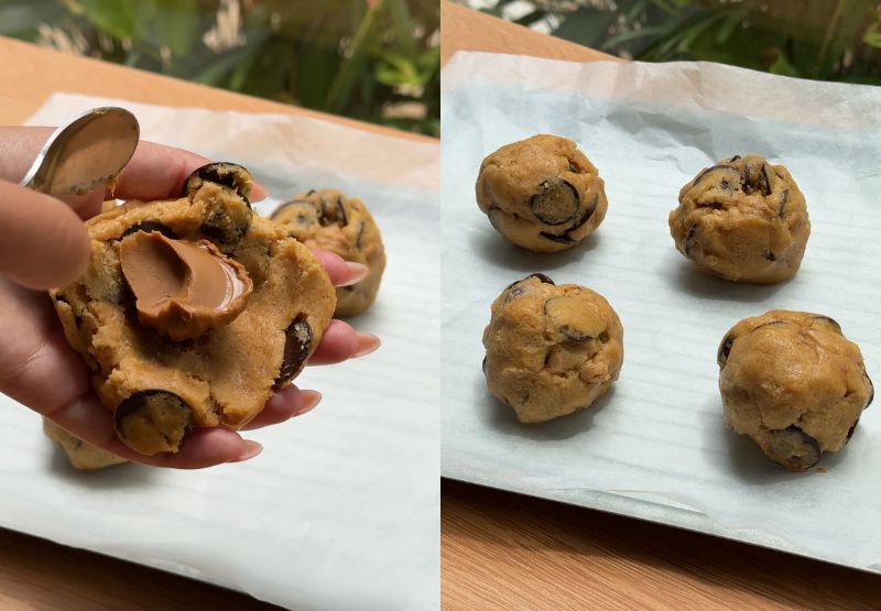 lacing a teaspoon of smooth Biscoff spread onto a flattened piece of chocolate chip cookie dough. Wrapping the cookie dough around the cookie butter filling and rolling it into a tightly sealed ball.
