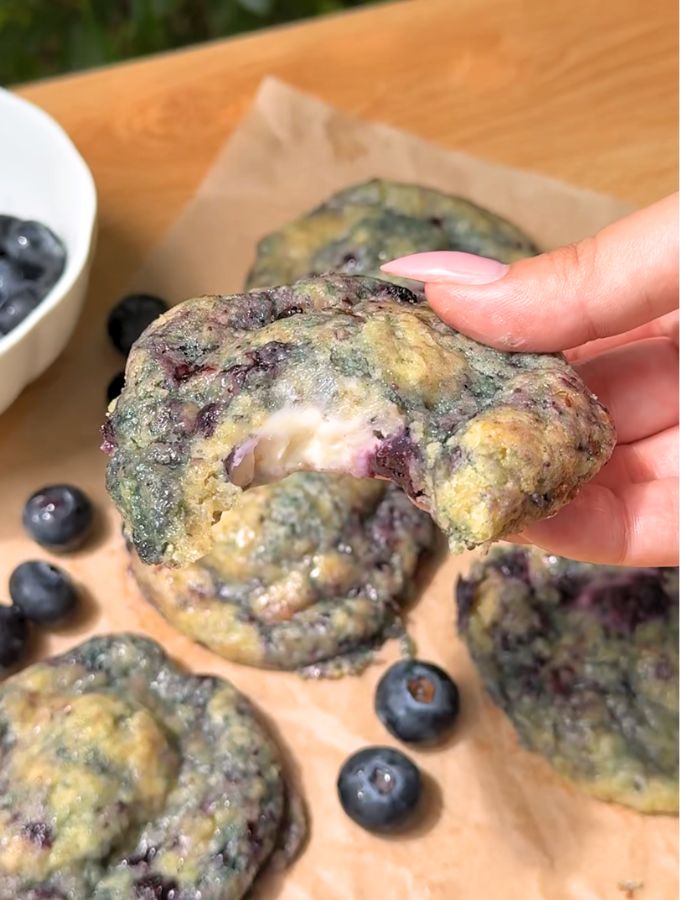 Bite missing from a blueberry cheesecake cookie.