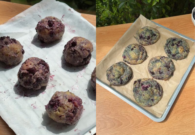 Large, stuffed blueberry cheesecake cookie dough balls spaced 3 inches apart on a large baking sheet lined with parchment paper before entering the oven. Golden brown blueberry cheesecake cookies fresh out of the oven resting on a hot baking sheet, showing crisp edges and soft centers with beautiful purple jam swirls.