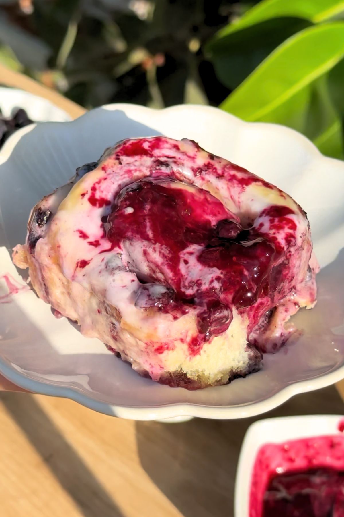 A single blueberry cinnamon roll on a plate.