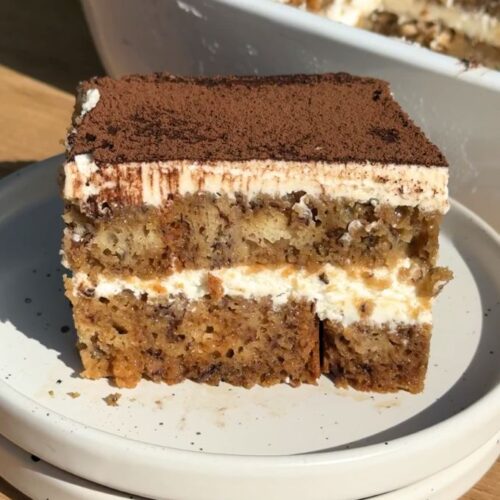 Slice of banana bread tiramisu on a white plate.