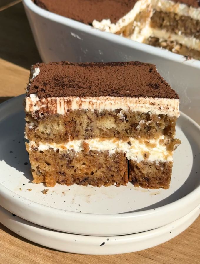 Slice of banana bread tiramisu on a white plate.