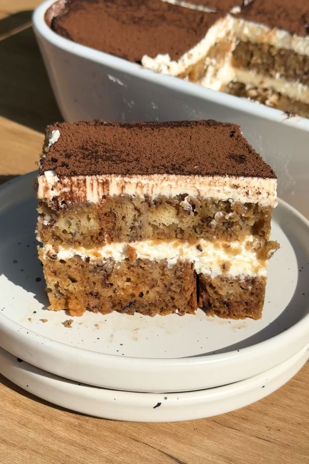 Slice of banana bread tiramisu on a white plate.