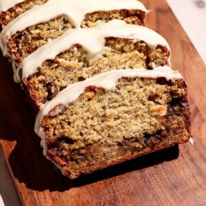 Cinnamon roll banana bread sliced on a wooden board.
