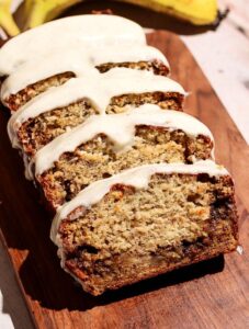 Cinnamon roll banana bread sliced on a wooden board.