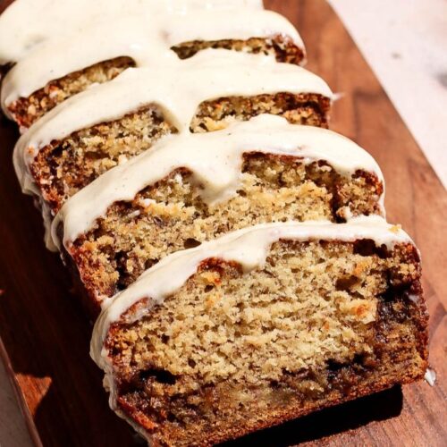 Cinnamon roll banana bread sliced on a wooden board.