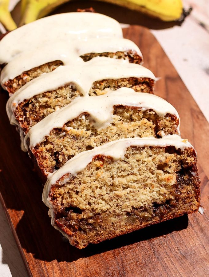 Cinnamon roll banana bread sliced on a wooden board.