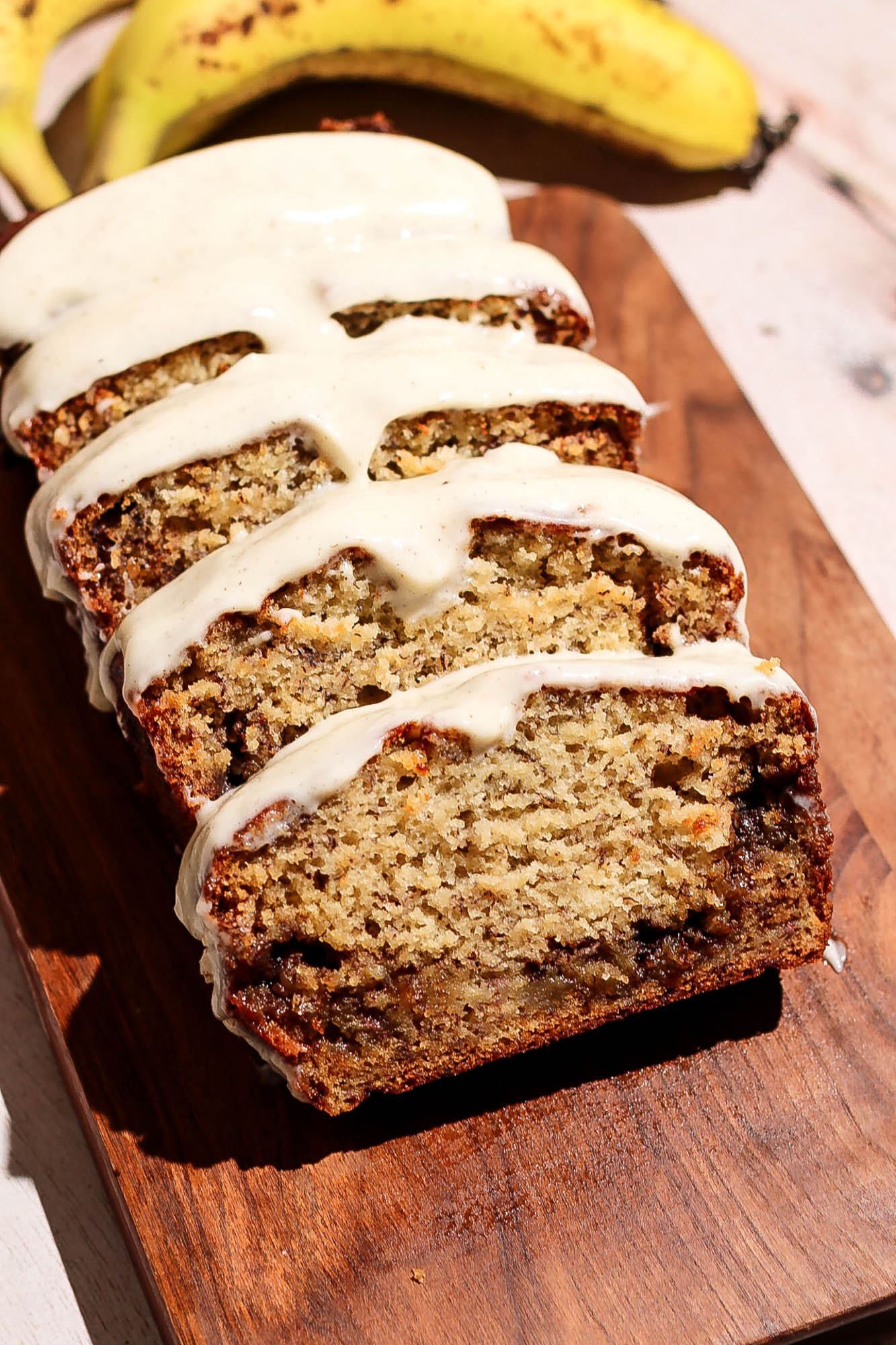 Cinnamon roll banana bread sliced on a wooden board.