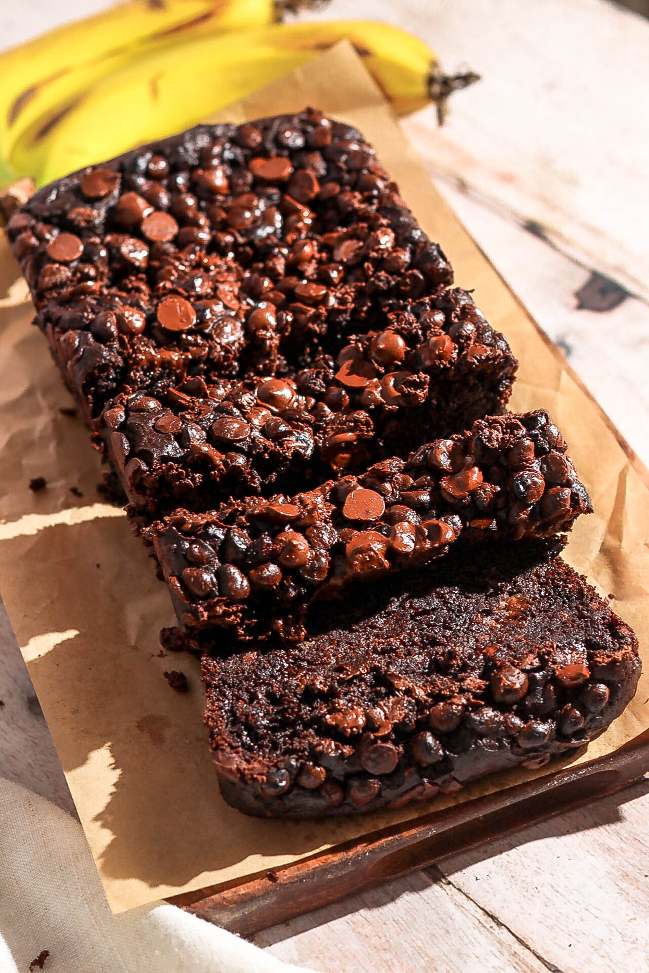 Double chocolate banana bread sliced on a brown parchment paper.