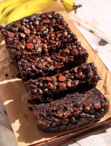 Double chocolate banana bread sliced on a brown parchment paper.