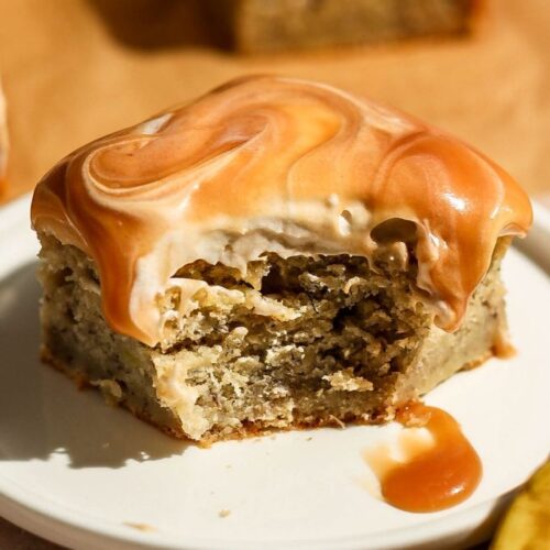 A final close-up view of a bitten slice of caramel banana cake on a white plate, showcasing the rich caramel glaze and soft crumb texture.