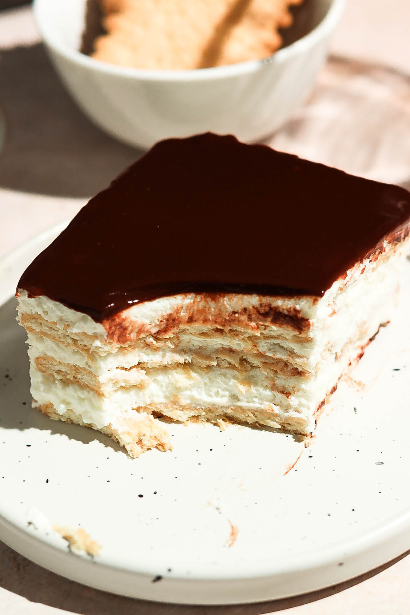 Close-up of a chocolate eclair cake slice with a bite taken, showing its rich texture and layers.