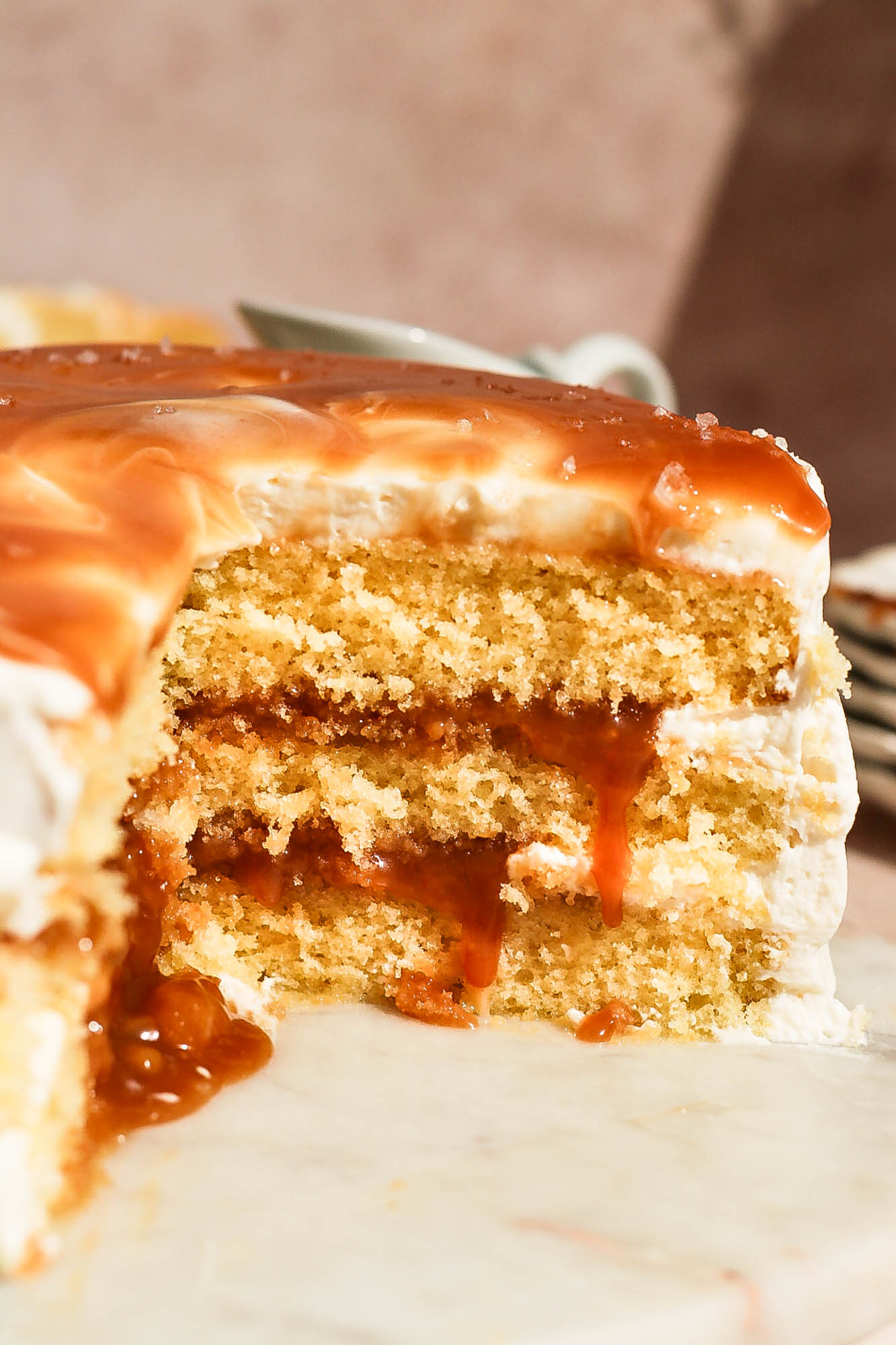 Close-up of the sliced cake revealing thick layers of caramel oozing between the moist sponge layers.